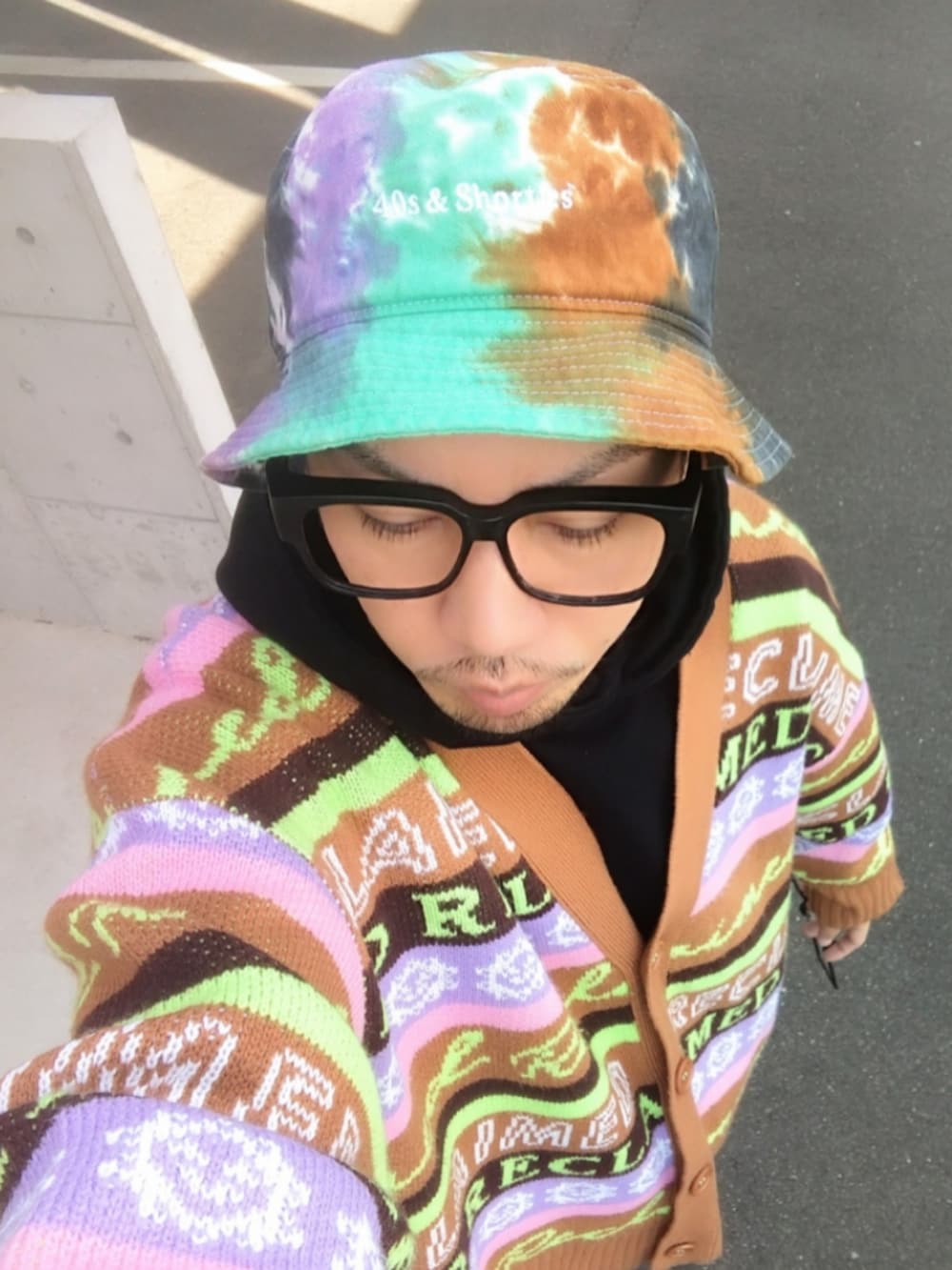 ブラック系のパーカー、ブラウン系のカーディガン/ボレロ、ブラック系のデニムパンツを着用したメンズの冬コーディネートの3枚目の写真