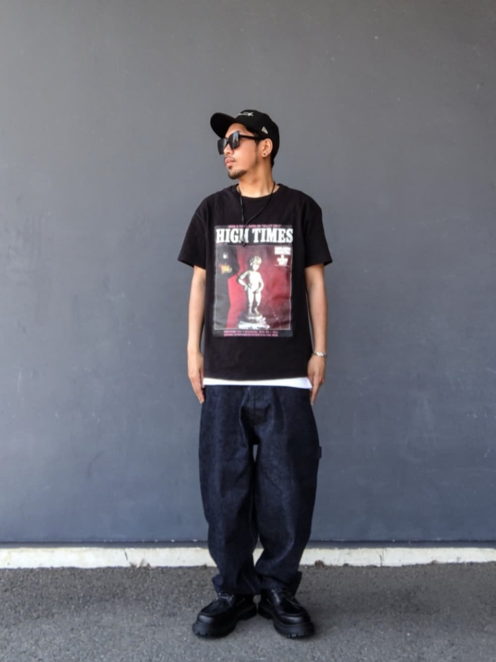 ブラック系のTシャツ/カットソー、ブルー系のデニムパンツ、ブラック系のモカシン/デッキシューズを着用したメンズの夏コーディネートの2枚目の写真