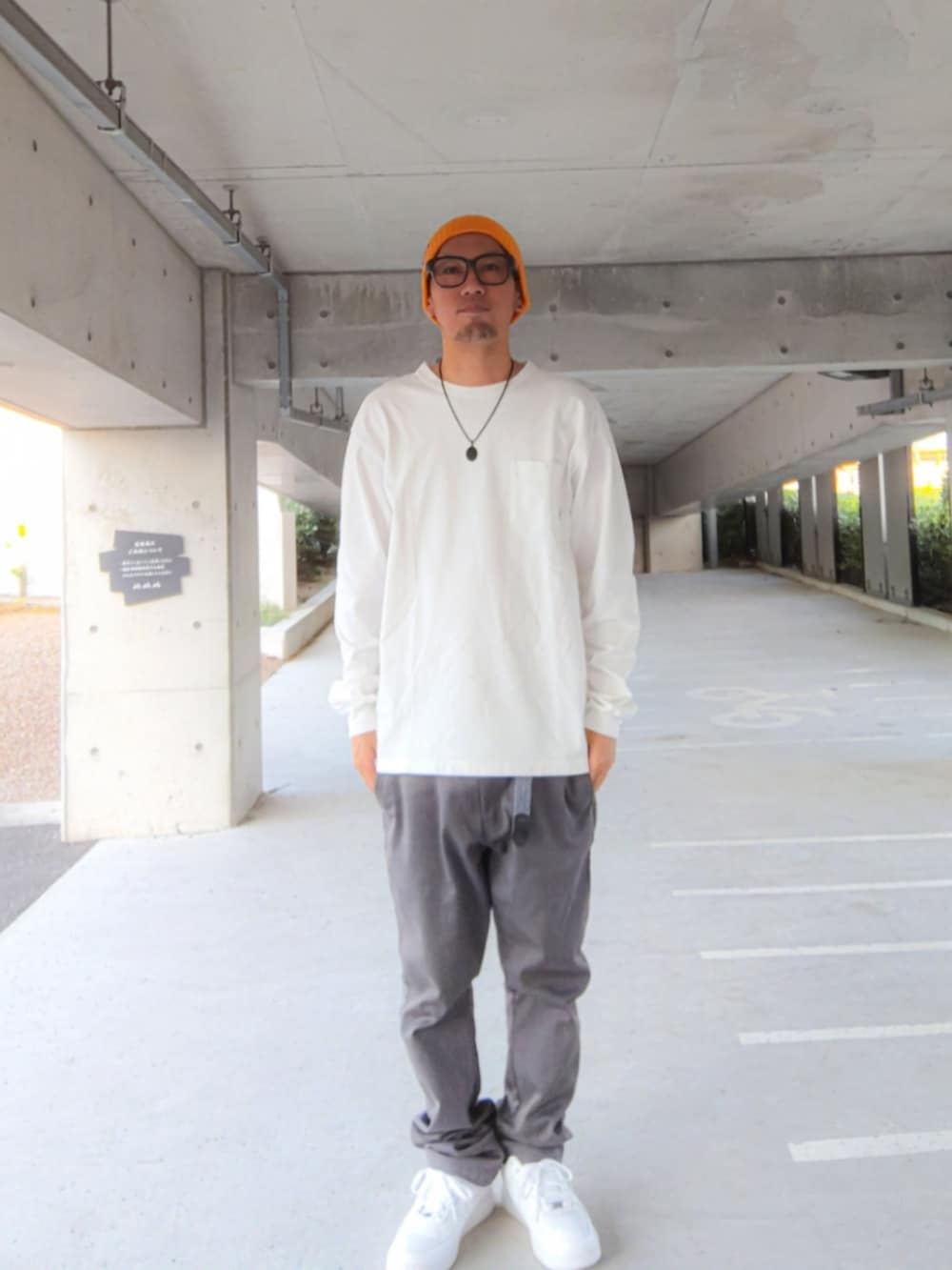ホワイト系のTシャツ/カットソー、グレー系のチノパンツ、ホワイト系のスニーカーを着用したメンズの秋コーディネートの2枚目の写真