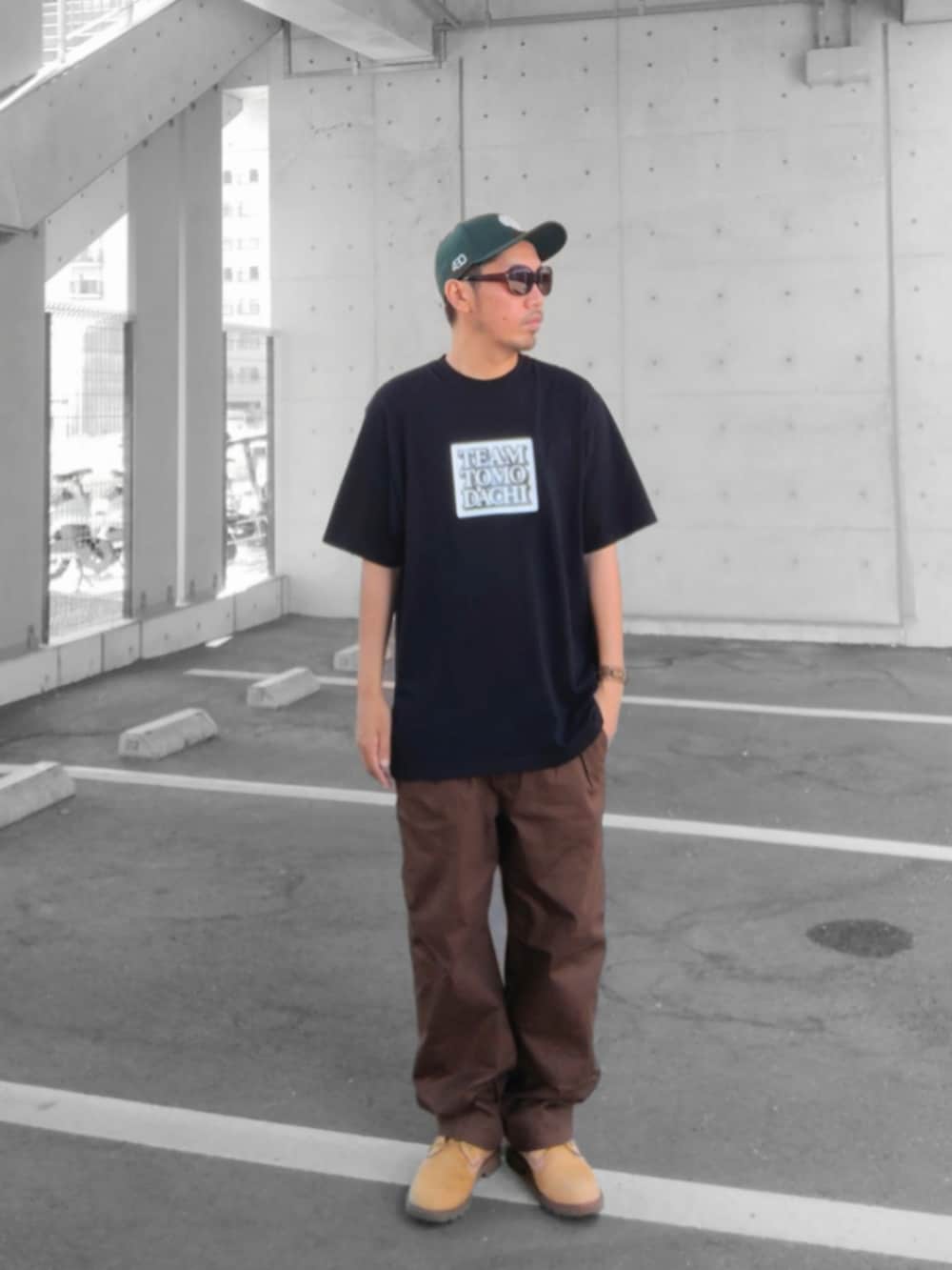 ブラック系のTシャツ/カットソー、ブラウン系のその他パンツ、イエロー系のブーツを着用したメンズの秋コーディネートの2枚目の写真