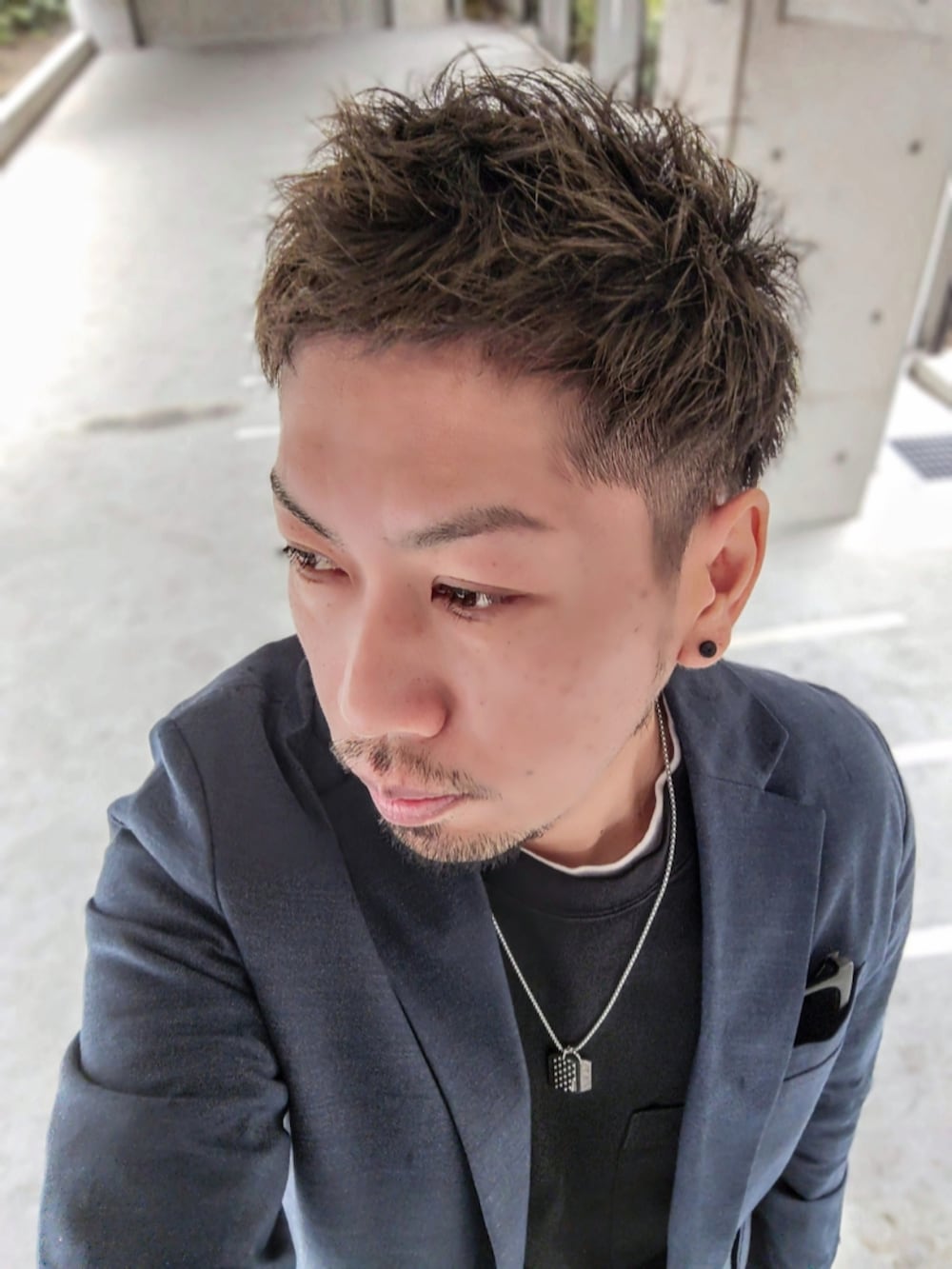 ブルー系のテーラードジャケット、ブラック系のTシャツ/カットソー、ブラック系のチノパンツを着用したメンズの春コーディネートの2枚目の写真