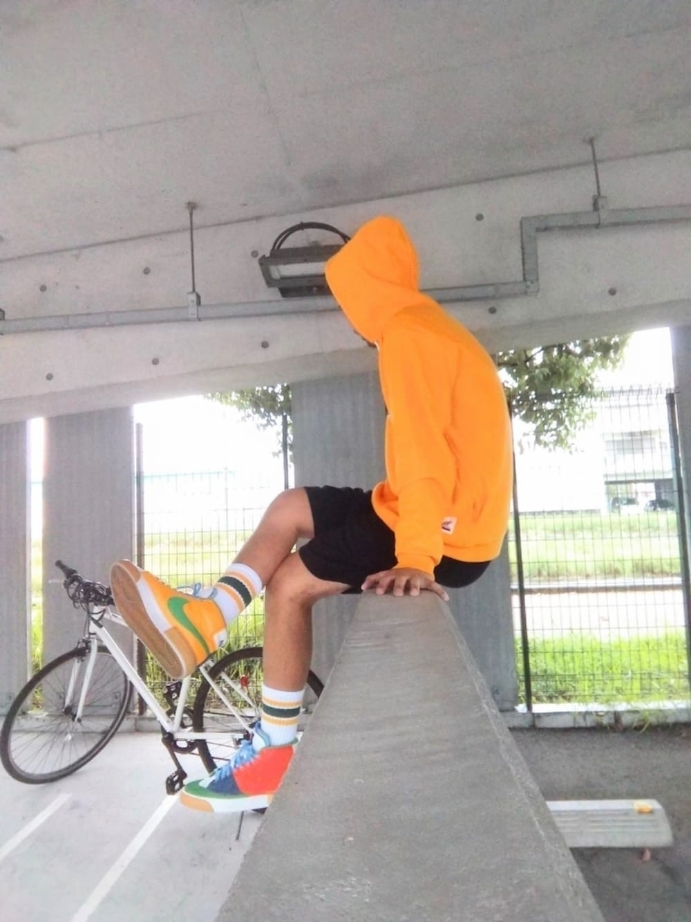 イエロー系のパーカー、ブラック系のその他パンツ、オレンジ系のスニーカーを着用したメンズの秋コーディネートの2枚目の写真