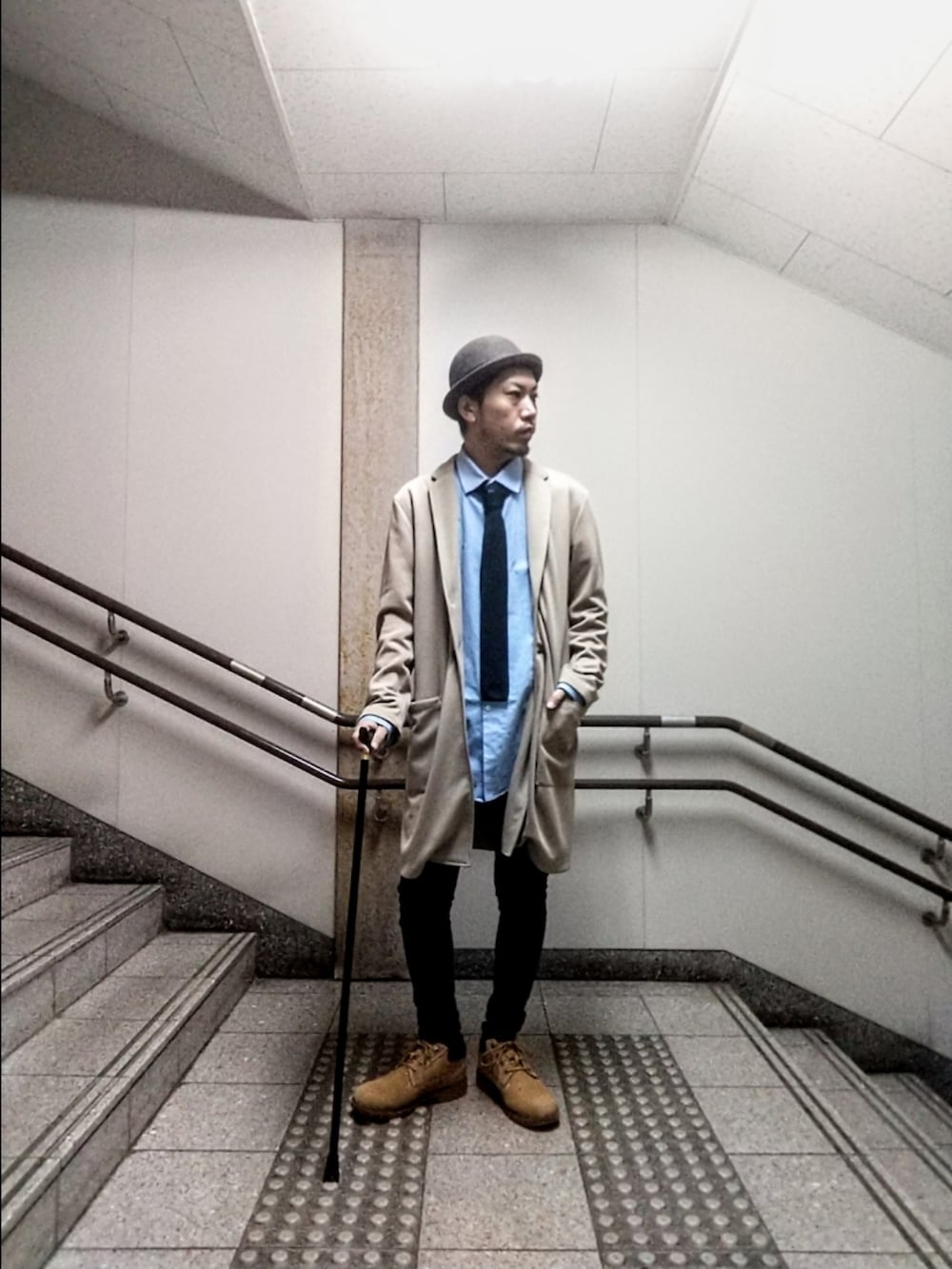 ベージュ系のチェスターコート、ブルー系のシャツ/ブラウス、ブラック系のデニムパンツを着用したメンズの秋コーディネートの3枚目の写真