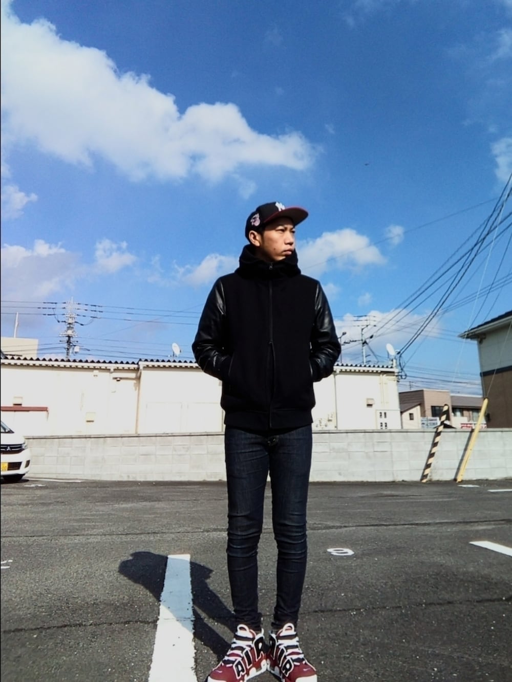 ブラック系のスタジャン、レッド系のTシャツ/カットソー、ブルー系のデニムパンツを着用したメンズの冬コーディネートの3枚目の写真