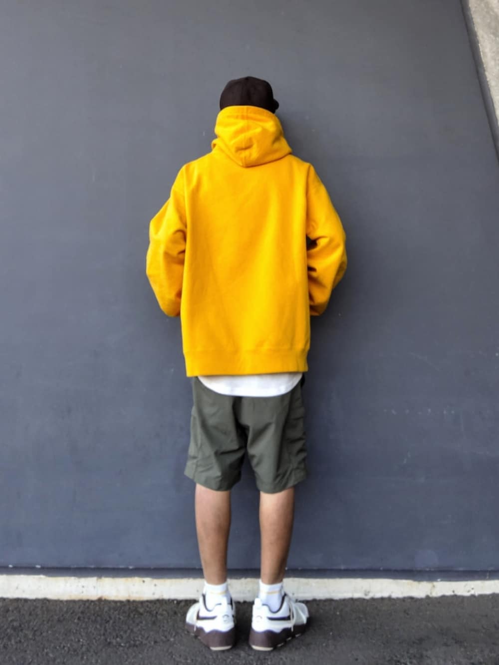 イエロー系のパーカー、ホワイト系のタンクトップ、グリーン系のその他パンツを着用したメンズの春コーディネートの3枚目の写真