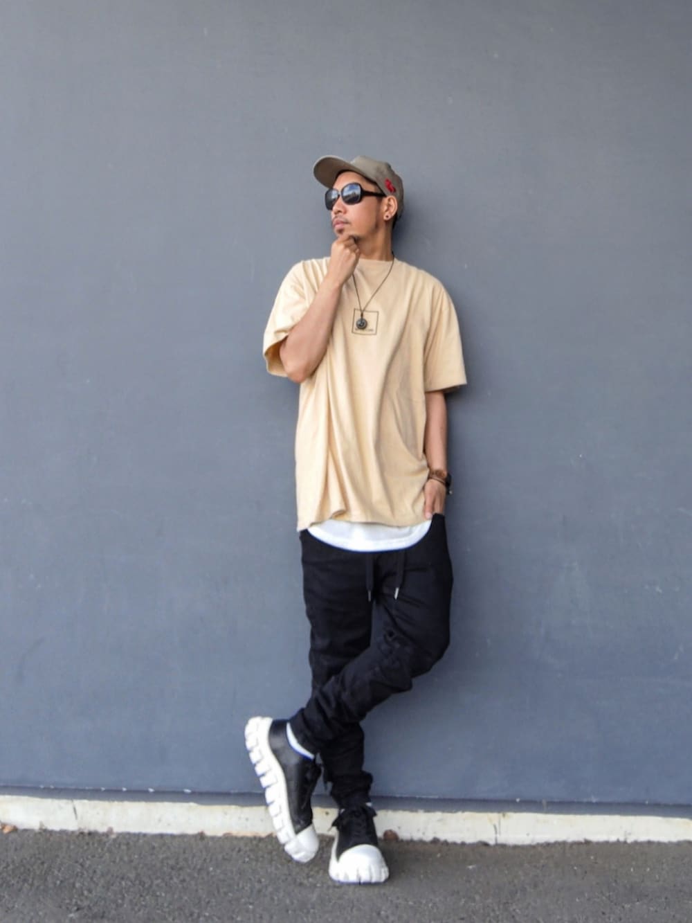 ベージュ系のTシャツ/カットソー、ホワイト系のタンクトップ、ブラック系のデニムパンツを着用したメンズの春コーディネートの2枚目の写真