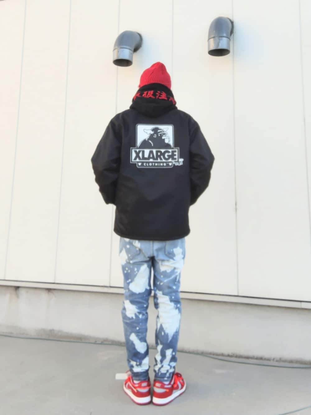 ブラック系のナイロンジャケット、ブラック系のパーカー、ブルー系のデニムパンツを着用したメンズの冬コーディネートの2枚目の写真