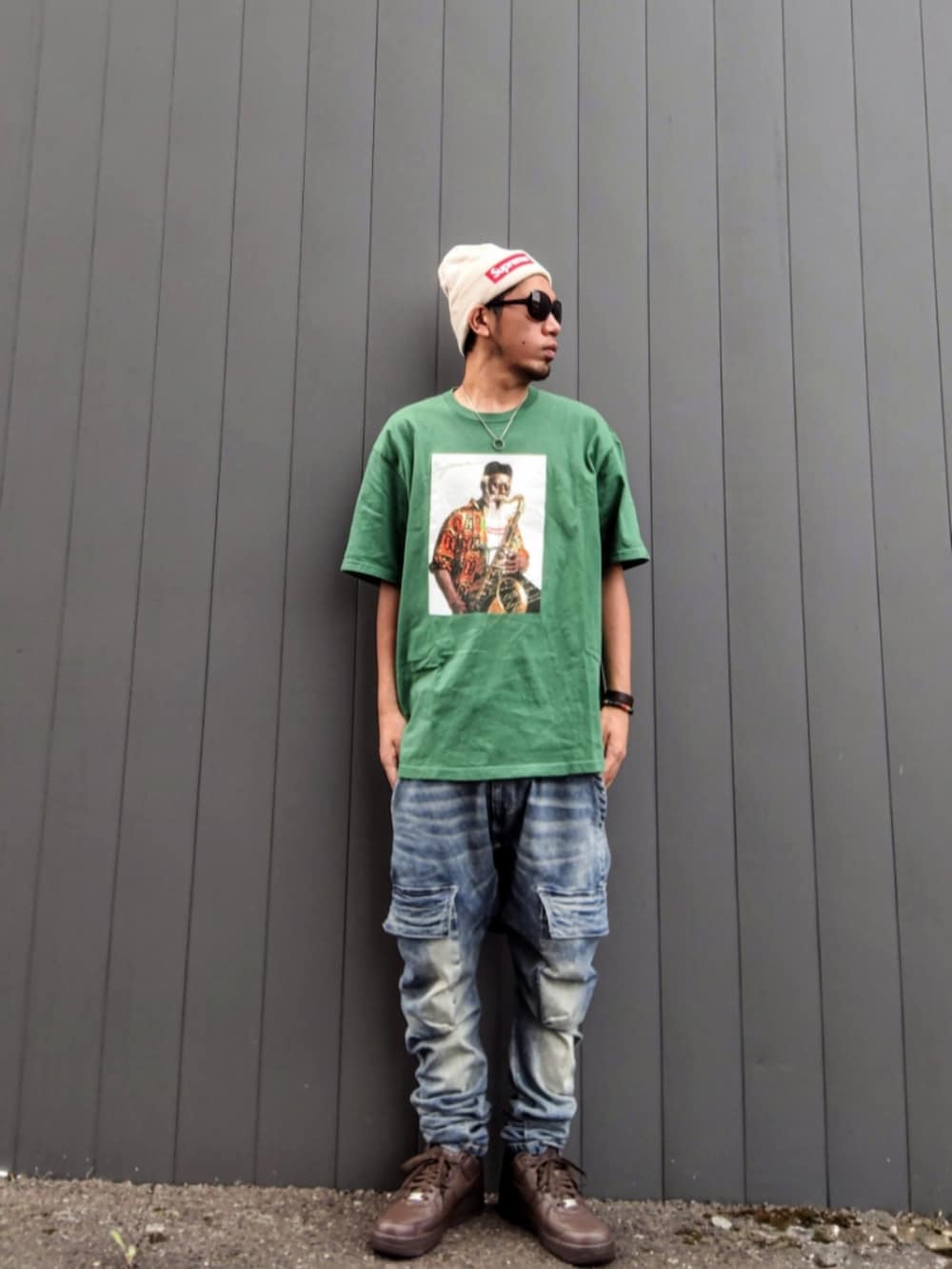 グリーン系のTシャツ/カットソー、ブルー系のデニムパンツ、ブラウン系のスニーカーを着用したメンズの秋コーディネートの3枚目の写真
