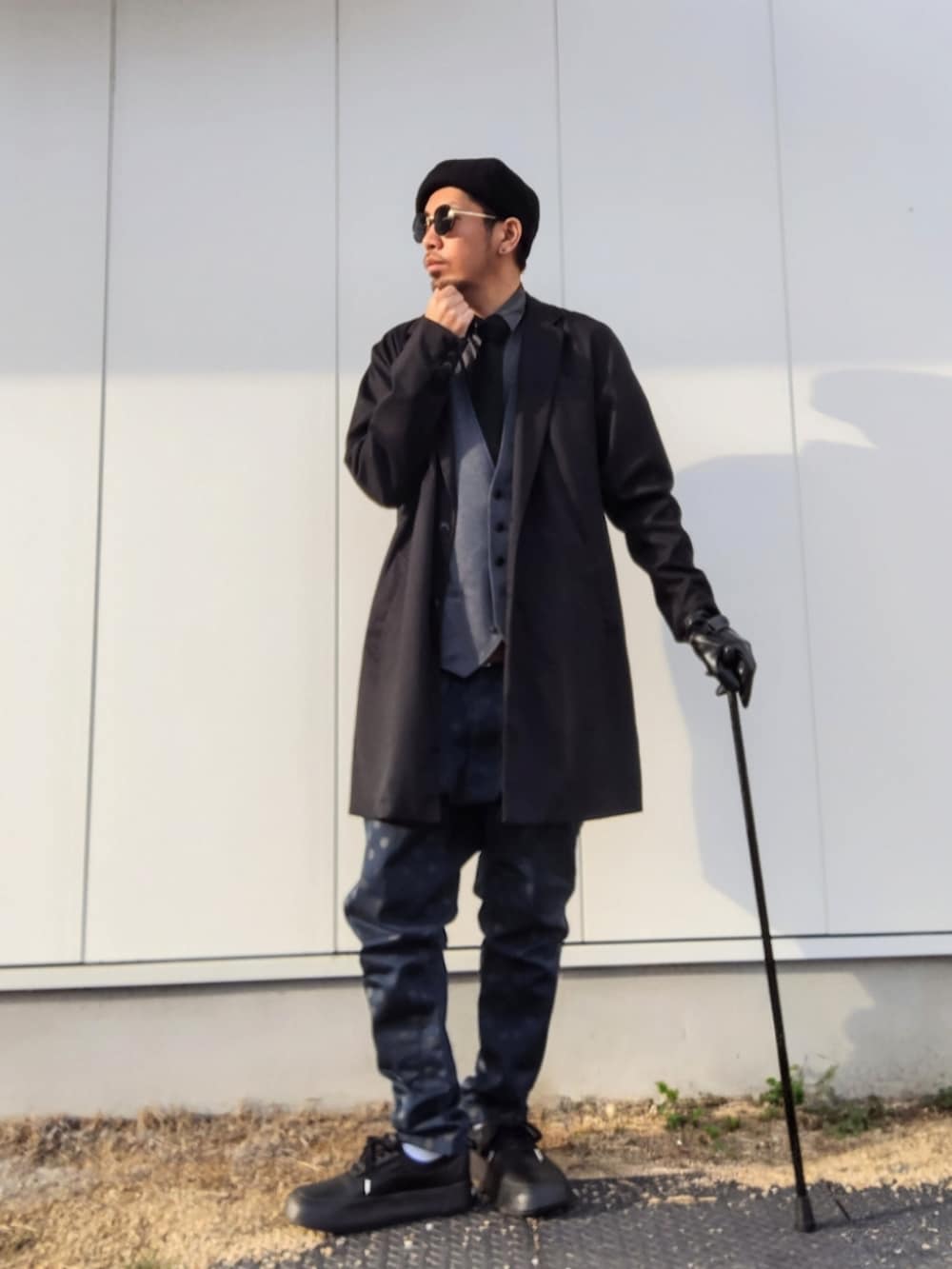 ブラック系のチェスターコート、ブラック系のシャツ/ブラウス、ブルー系のその他パンツを着用したメンズの春コーディネートの2枚目の写真