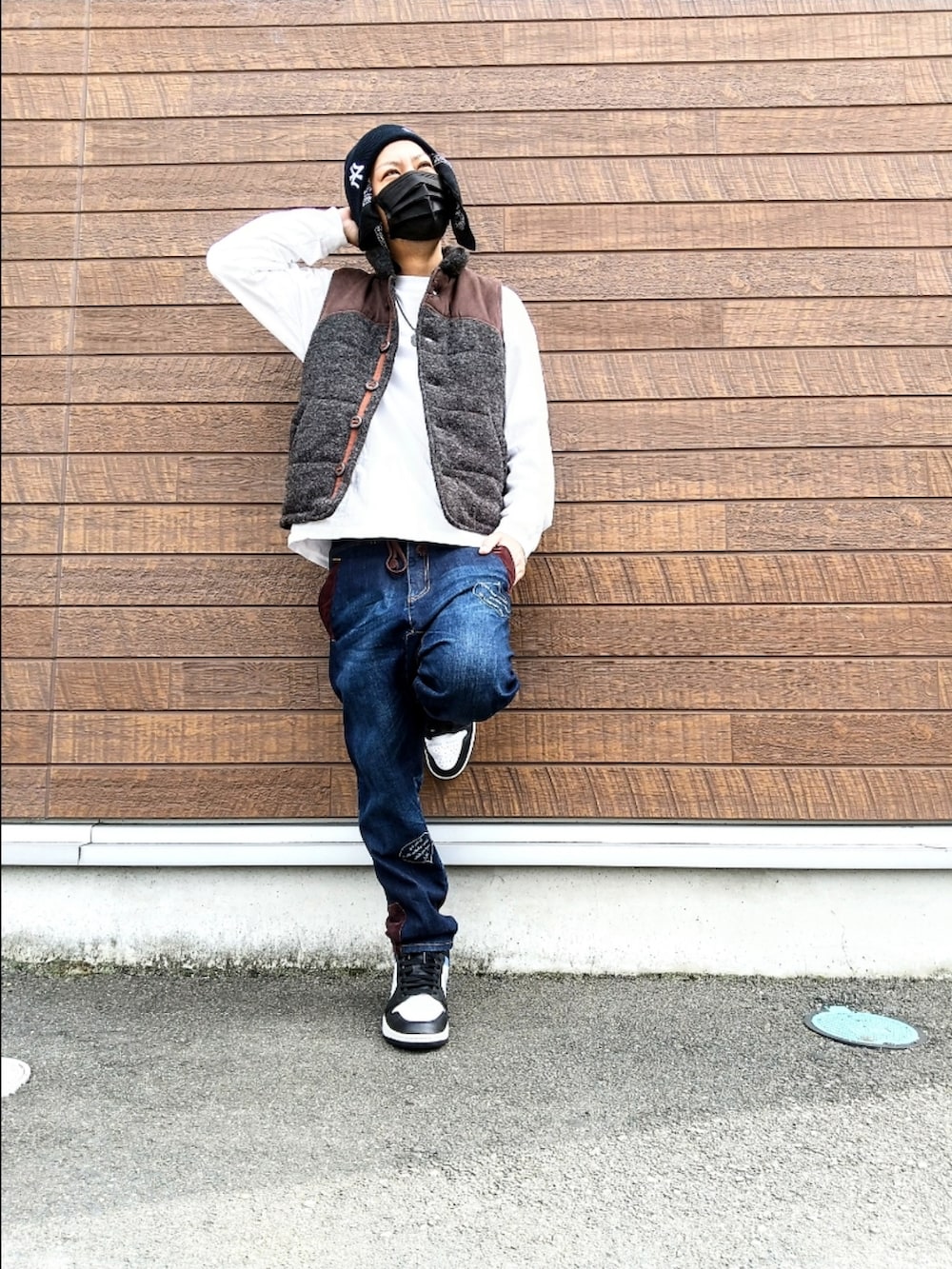 グレー系のベスト、ホワイト系のTシャツ/カットソー、ブルー系のデニムパンツを着用したメンズの秋コーディネートの3枚目の写真