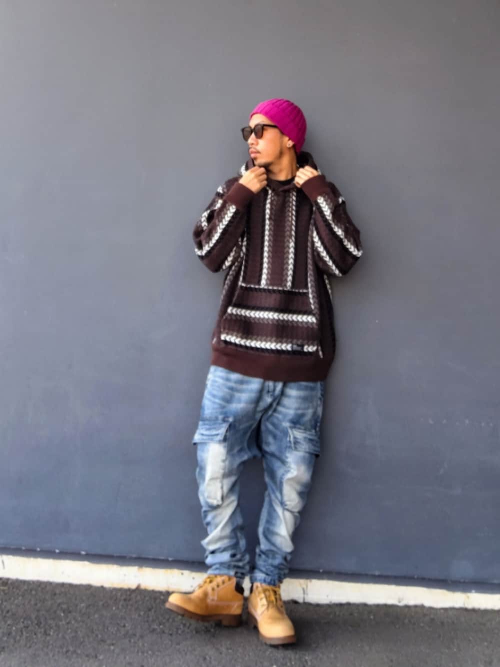 ブラウン系のパーカー、ブルー系のデニムパンツ、イエロー系のブーツを着用したメンズの冬コーディネートの2枚目の写真