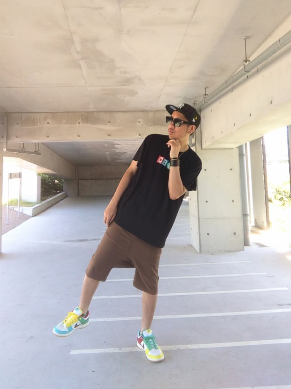 ブラック系のTシャツ/カットソー、ブラウン系のその他パンツ、その他のスニーカーを着用したメンズの夏コーディネートの3枚目の写真