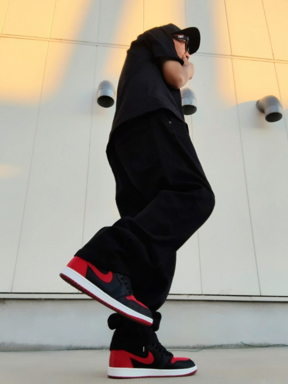 ブラック系のTシャツ/カットソー、ブラック系のデニムパンツ、ブラック系のスニーカーを着用したメンズの夏コーディネートの2枚目の写真