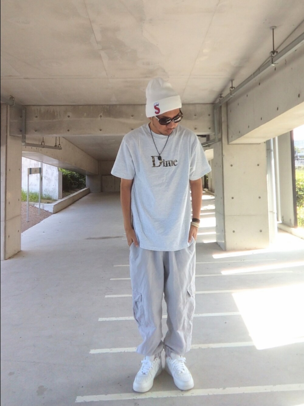 グレー系のTシャツ/カットソー、ホワイト系のカーゴパンツ、ホワイト系のスニーカーを着用したメンズの秋コーディネートの2枚目の写真