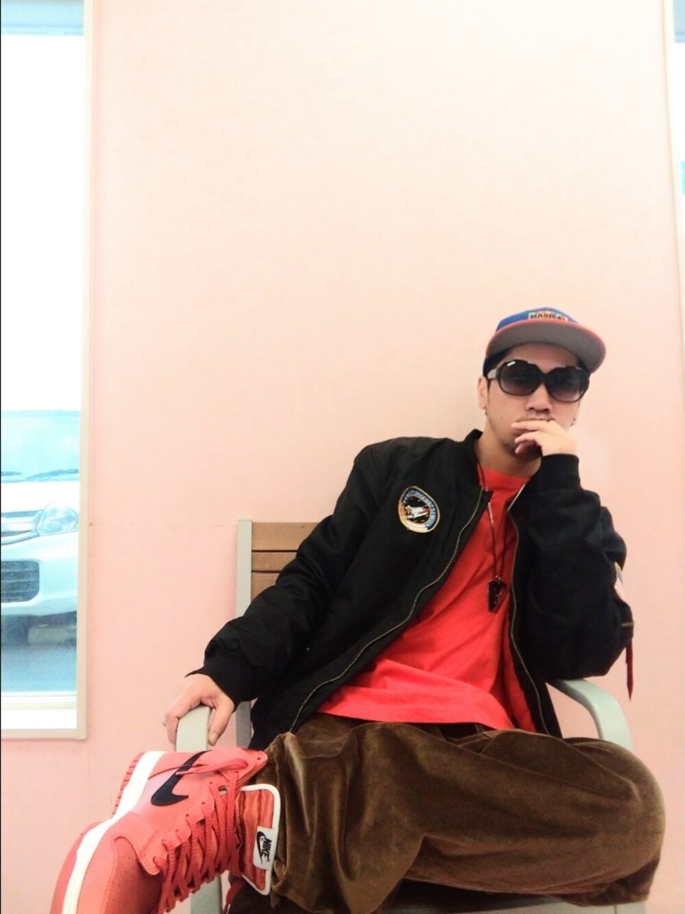 オレンジ系のスニーカー、ブラウン系のその他パンツ、ブラック系のMA-1を着用したメンズの春コーディネートの2枚目の写真