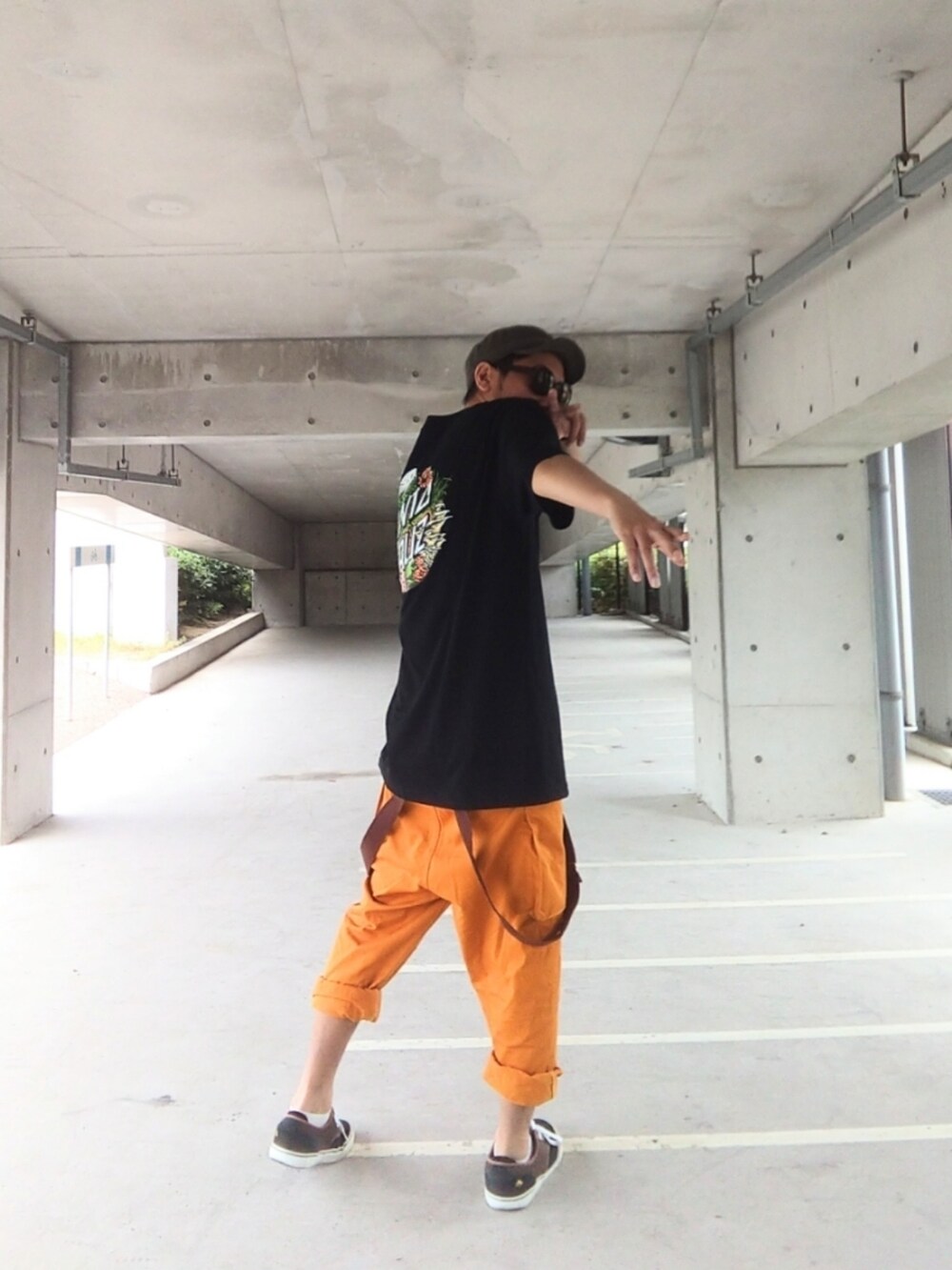 ブラック系のTシャツ/カットソー、オレンジ系のサロペット/オーバーオール、ブラック系のスニーカーを着用したメンズの夏コーディネートの3枚目の写真