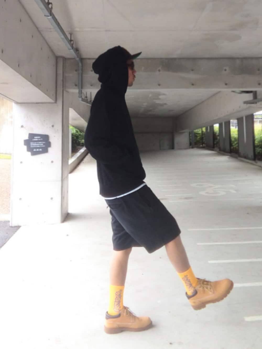 ブラック系のパーカー、ブラック系のその他パンツ、イエロー系のブーツを着用したメンズの春コーディネートの2枚目の写真