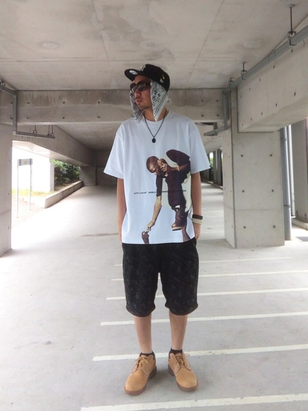 ホワイト系のTシャツ/カットソー、ブラック系のパンツ、イエロー系のブーツを着用したメンズの夏コーディネートの2枚目の写真