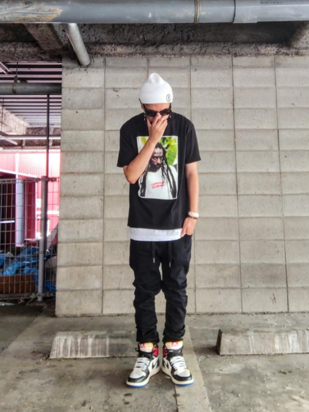 ブラック系のTシャツ/カットソー、ホワイト系のタンクトップ、ブラック系のデニムパンツを着用したメンズの夏コーディネートの2枚目の写真