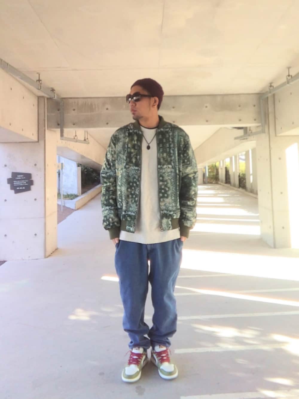 グリーン系のジャケット/アウター、ホワイト系のニット/セーター、ブルー系のデニムパンツを着用したメンズの冬コーディネートの2枚目の写真