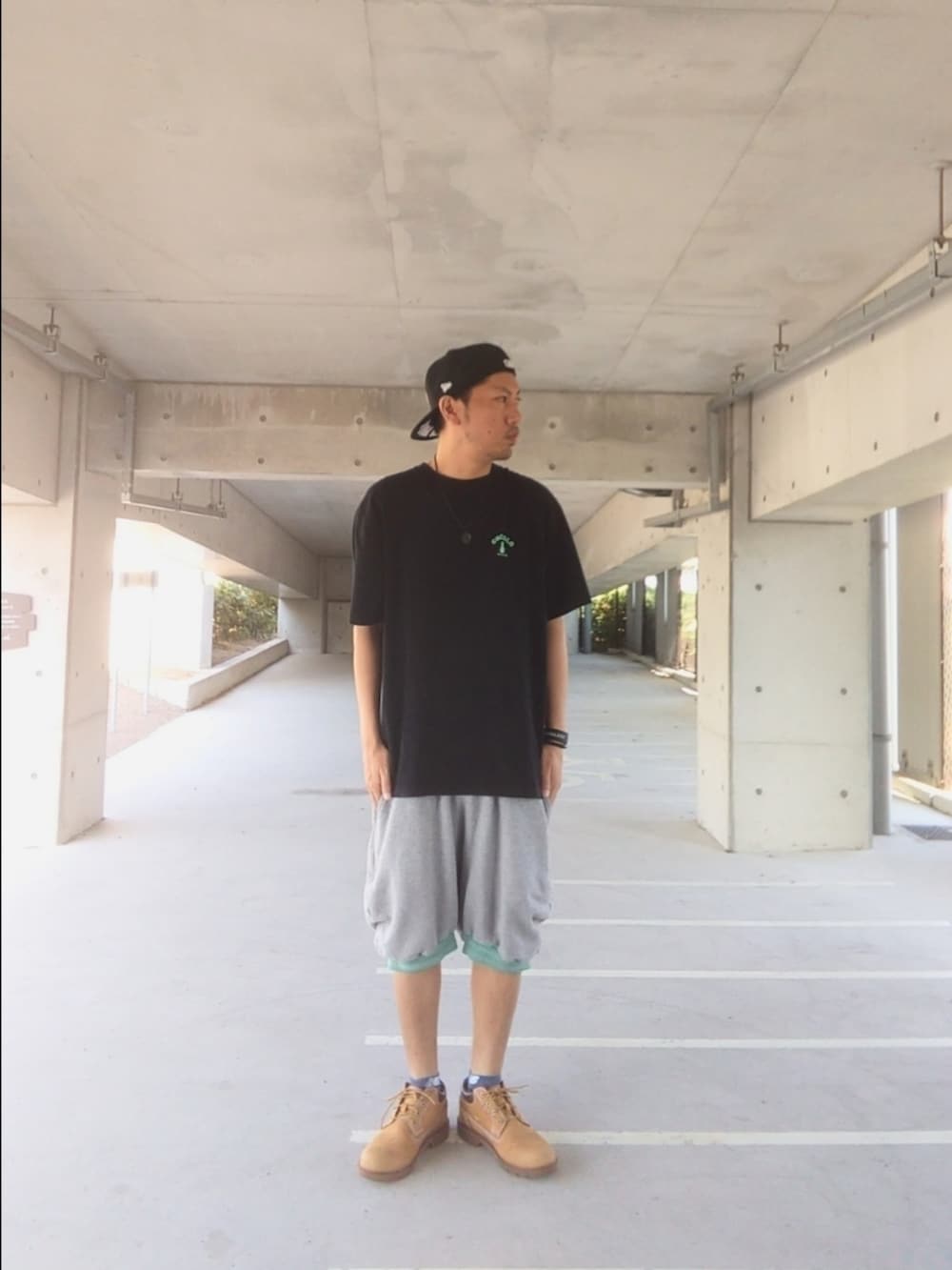 ブラック系のTシャツ/カットソー、グレー系のその他パンツ、イエロー系のブーツを着用したメンズの夏コーディネートの2枚目の写真