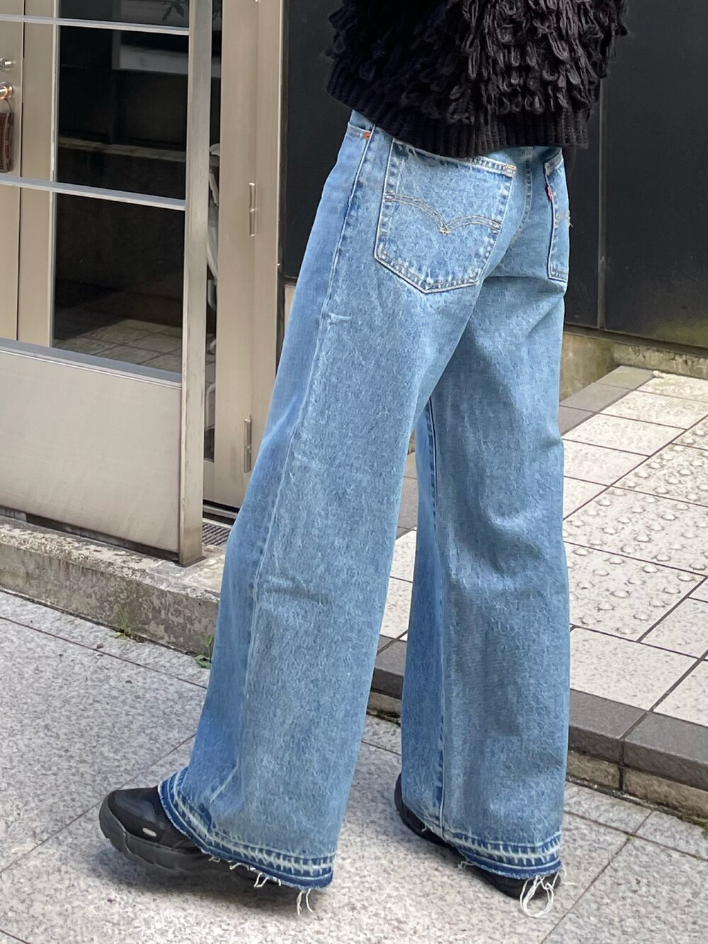 ブルー系のデニムパンツ、ブラック系のベスト、ブラック系のTシャツ/カットソーを着用したレディースの秋コーディネートの9枚目の写真