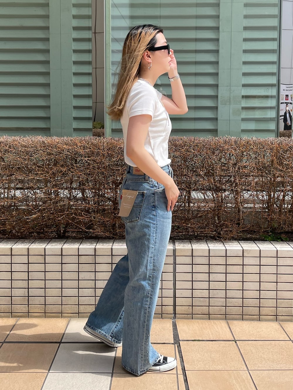 ブルー系のデニムパンツ、ホワイト系のTシャツ/カットソー、シルバー系のネックレスを着用したレディースの春コーディネートの3枚目の写真