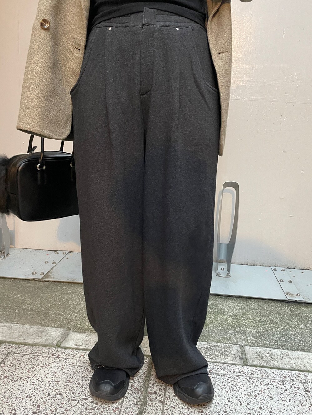 グレー系のテーラードジャケット、グレー系のスウェットパンツ、ブラック系のハンドバッグを着用したレディースの秋コーディネートの5枚目の写真