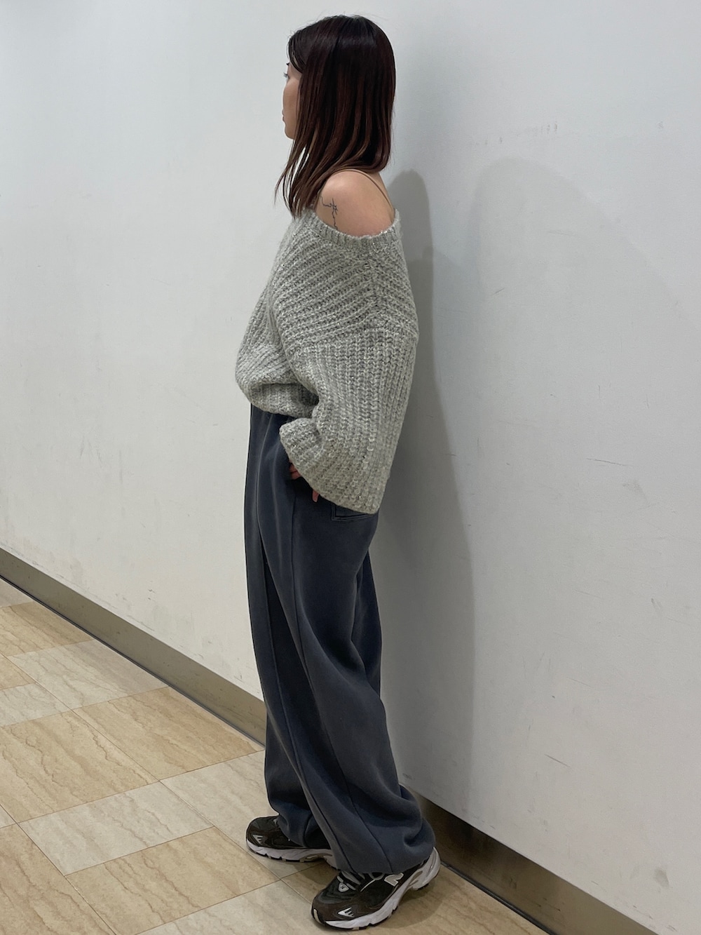 グレー系のニット/セーター、グレー系のスウェットパンツを着用したレディースの冬コーディネートの2枚目の写真