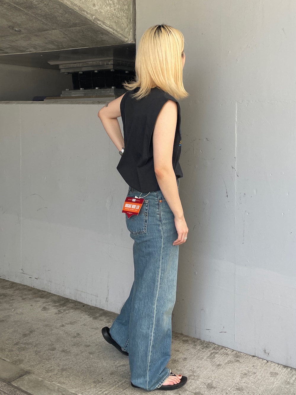 ブルー系のデニムパンツ、グレー系のタンクトップを着用したレディースの夏コーディネートの2枚目の写真