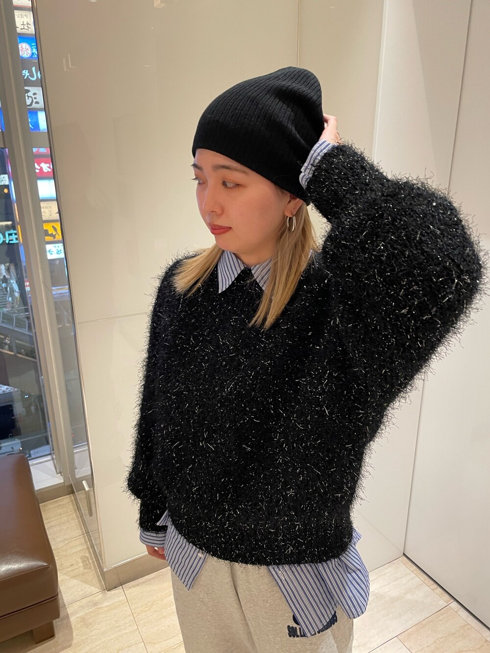 ブラック系のニット/セーター、ブルー系のシャツ/ブラウス、グレー系のスウェットパンツを着用したレディースの秋コーディネートの3枚目の写真