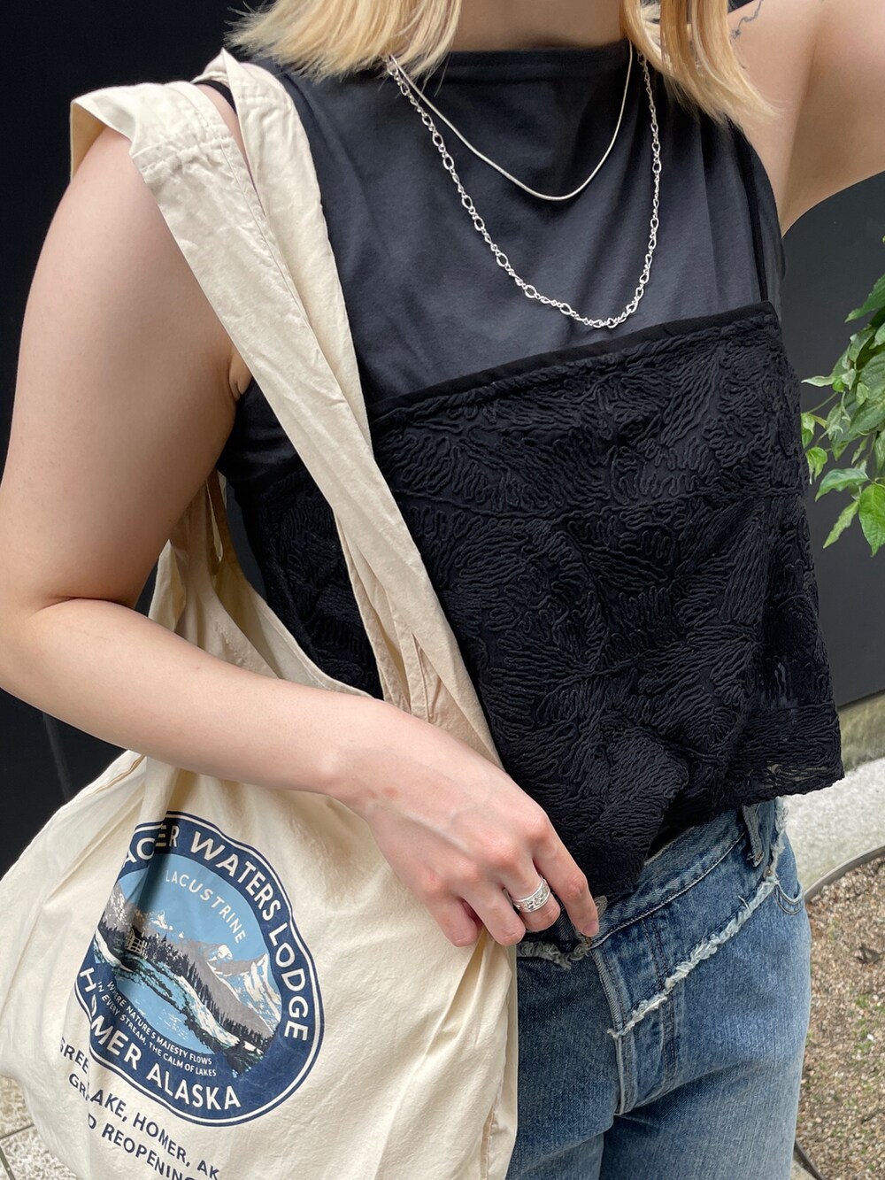 ブルー系のデニムパンツ、ブラック系のタンクトップ、ブラック系のキャミソールを着用したレディースの夏コーディネートの7枚目の写真