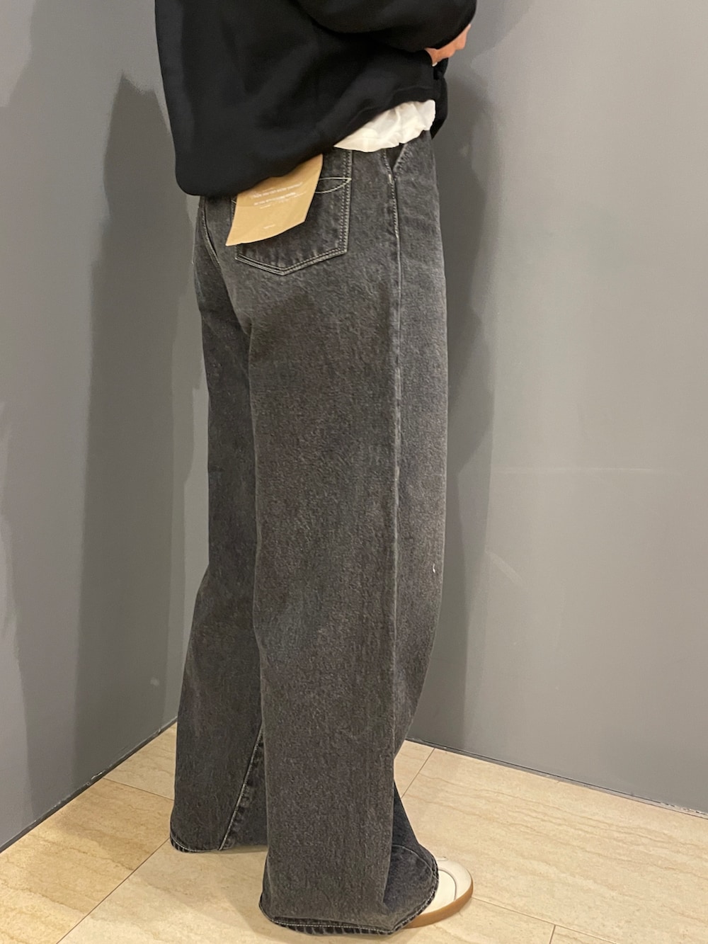 ブラック系のパーカー、ホワイト系のTシャツ/カットソー、ブラック系のデニムパンツを着用したレディースの秋コーディネートの8枚目の写真