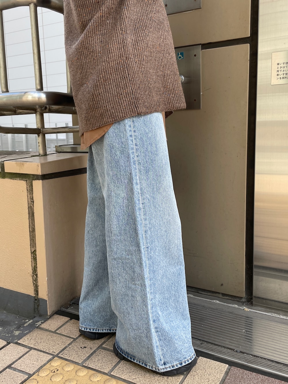 ブラウン系のカーディガン/ボレロ、ブルー系のデニムパンツ、ブラック系のハンドバッグを着用したレディースの秋コーディネートの8枚目の写真