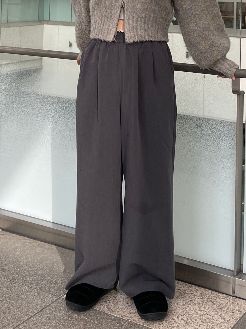 グレー系のその他パンツ、グレー系のカーディガン/ボレロ、シルバー系のネックレスを着用したレディースの冬コーディネートの5枚目の写真