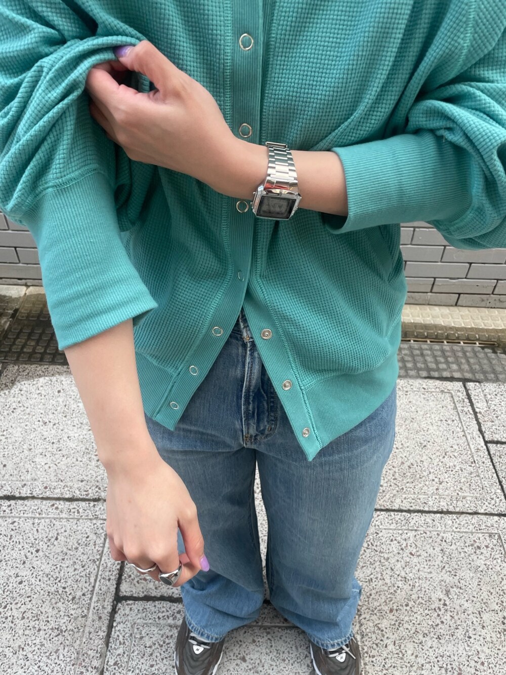 ブルー系のカーディガン/ボレロ、ブルー系のデニムパンツ、ホワイト系のキャップを着用したレディースの冬コーディネートの6枚目の写真