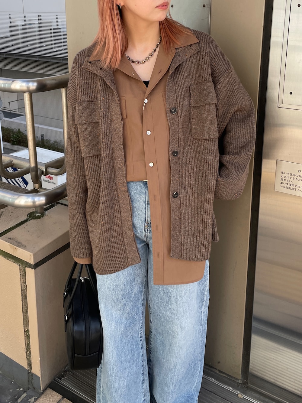 ブラウン系のカーディガン/ボレロ、ブルー系のデニムパンツ、ブラック系のハンドバッグを着用したレディースの秋コーディネートの6枚目の写真