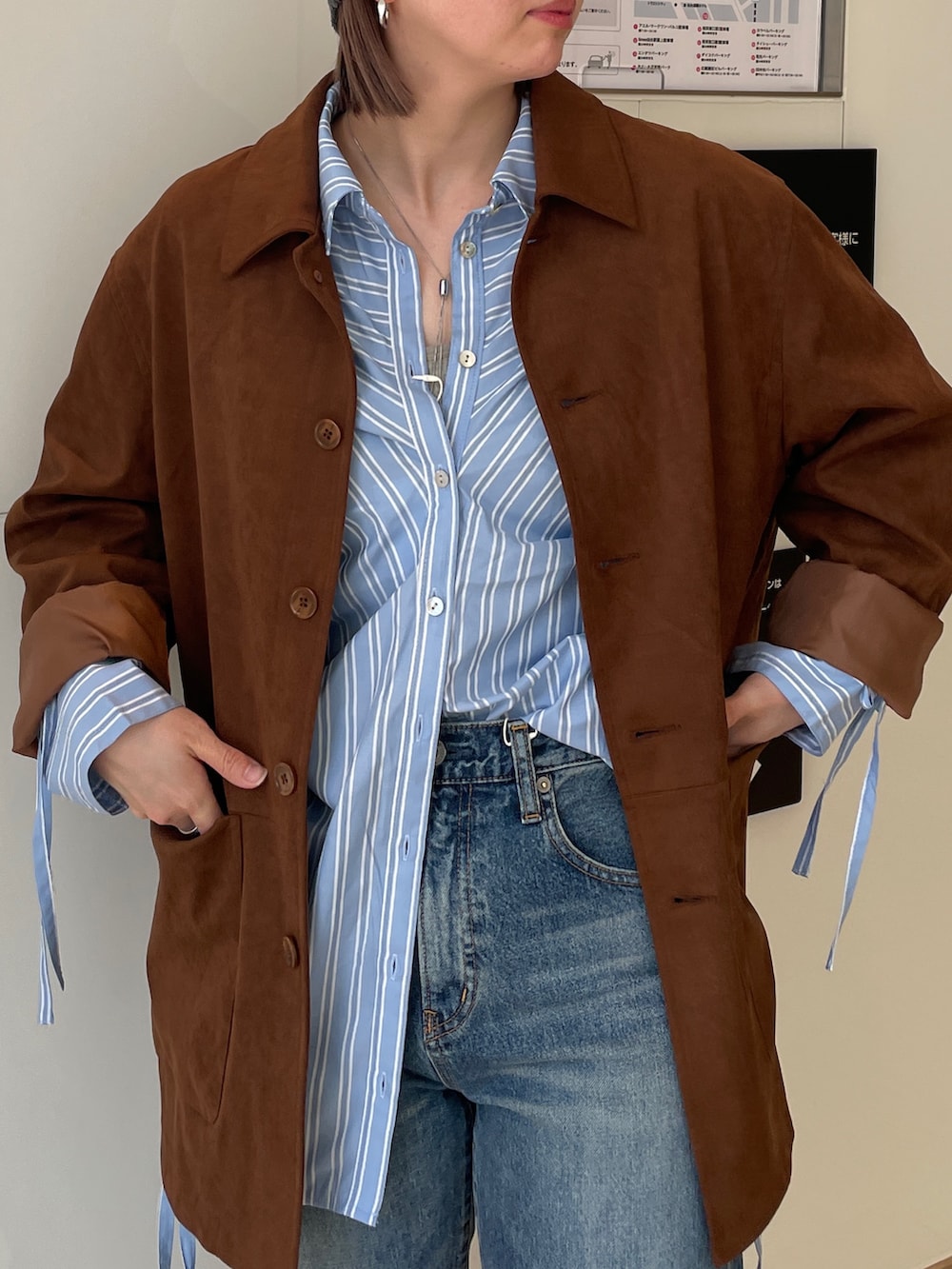 ブラウン系のテーラードジャケット、ブルー系のシャツ/ブラウス、ブルー系のデニムパンツを着用したレディースの春コーディネートの4枚目の写真