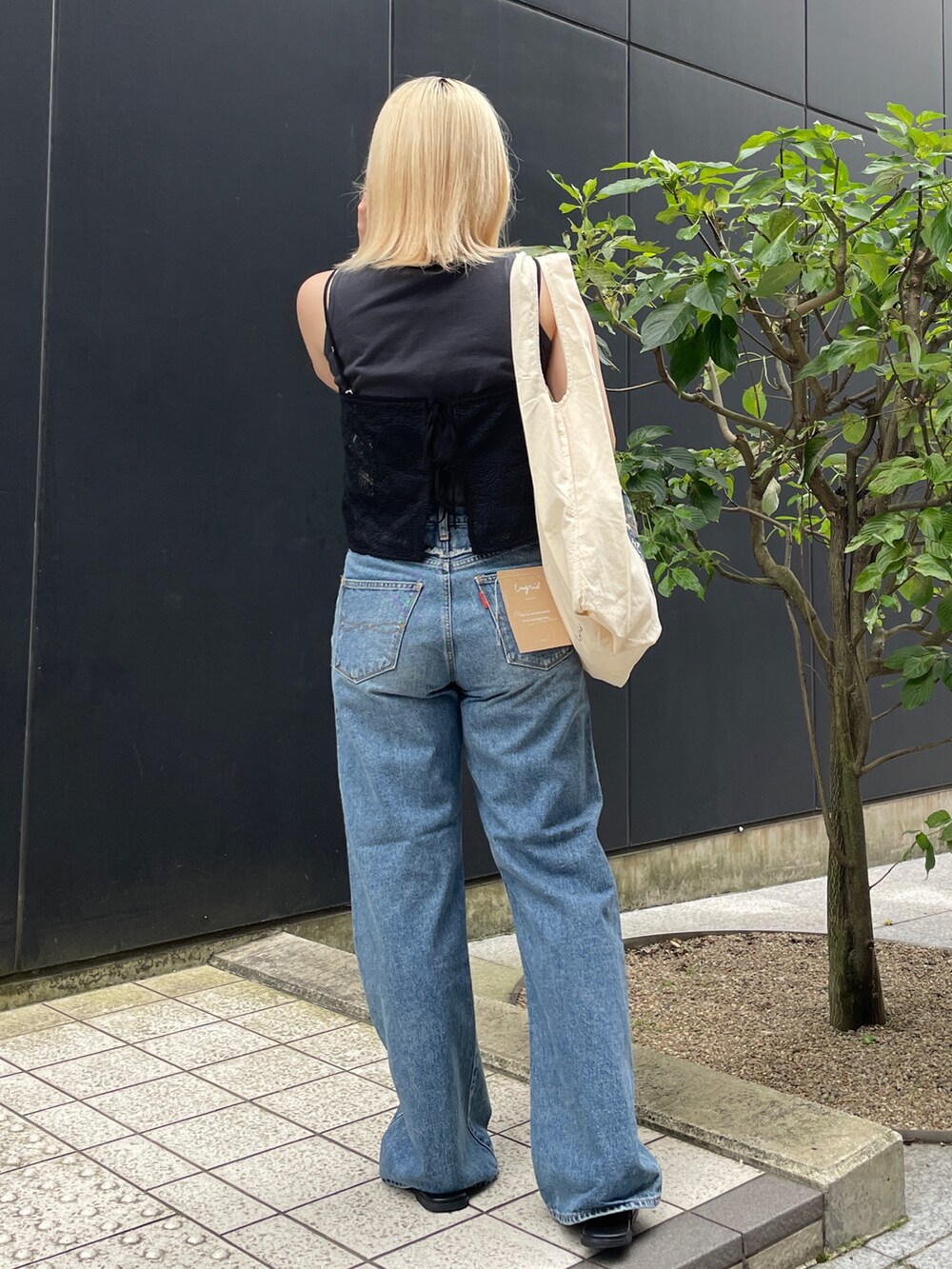 ブルー系のデニムパンツ、ブラック系のタンクトップ、ブラック系のキャミソールを着用したレディースの夏コーディネートの3枚目の写真