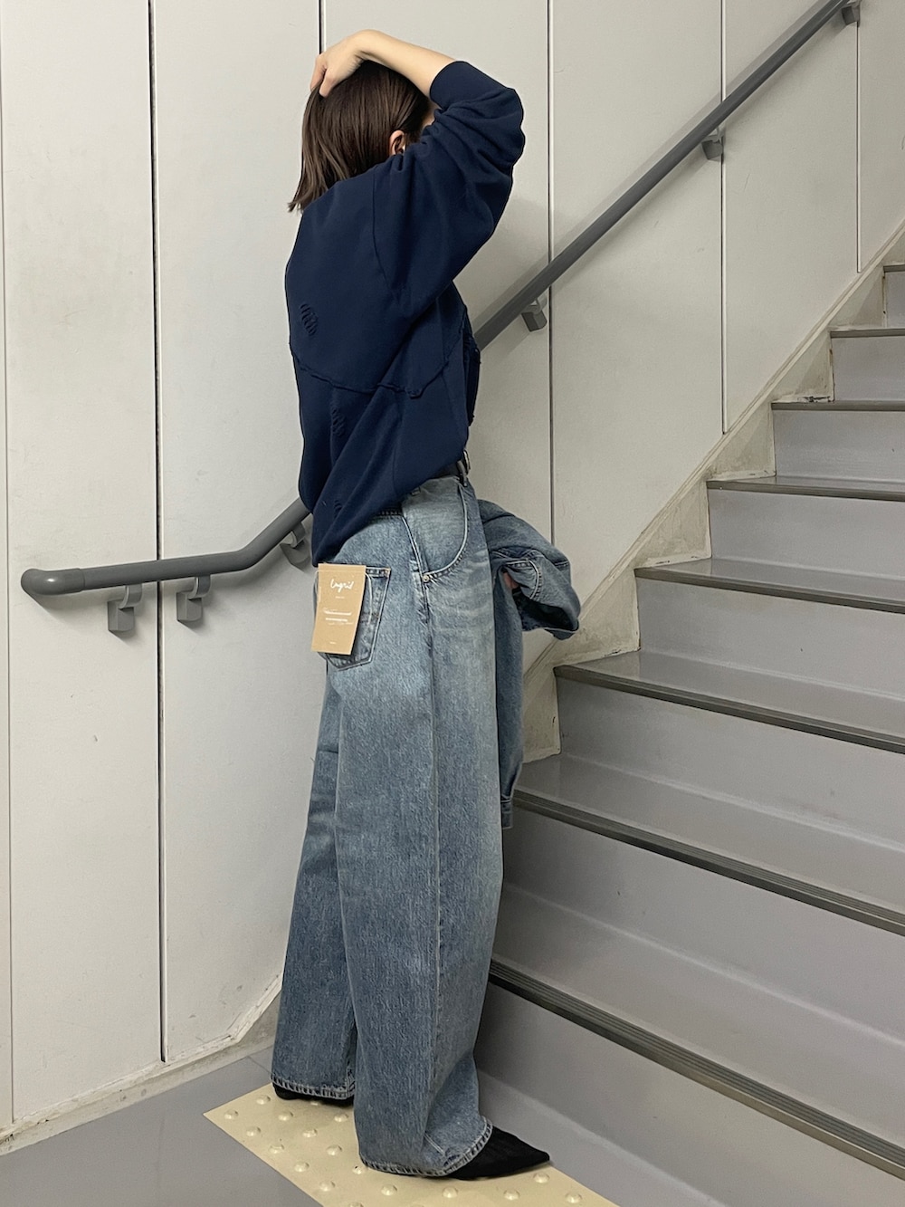 ブルー系のデニムパンツ、ブルー系のデニムジャケット、ブルー系のスウェットを着用したレディースの冬コーディネートの2枚目の写真