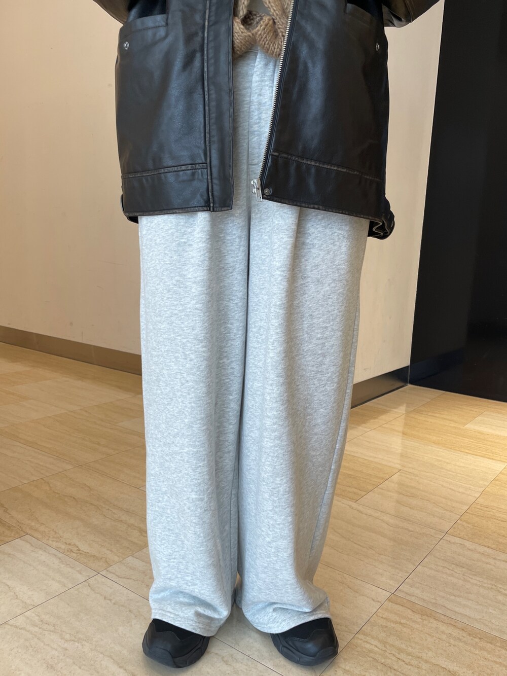 ブラック系のブルゾン、ブラウン系のニット/セーター、グレー系のスウェットパンツを着用したレディースの秋コーディネートの5枚目の写真