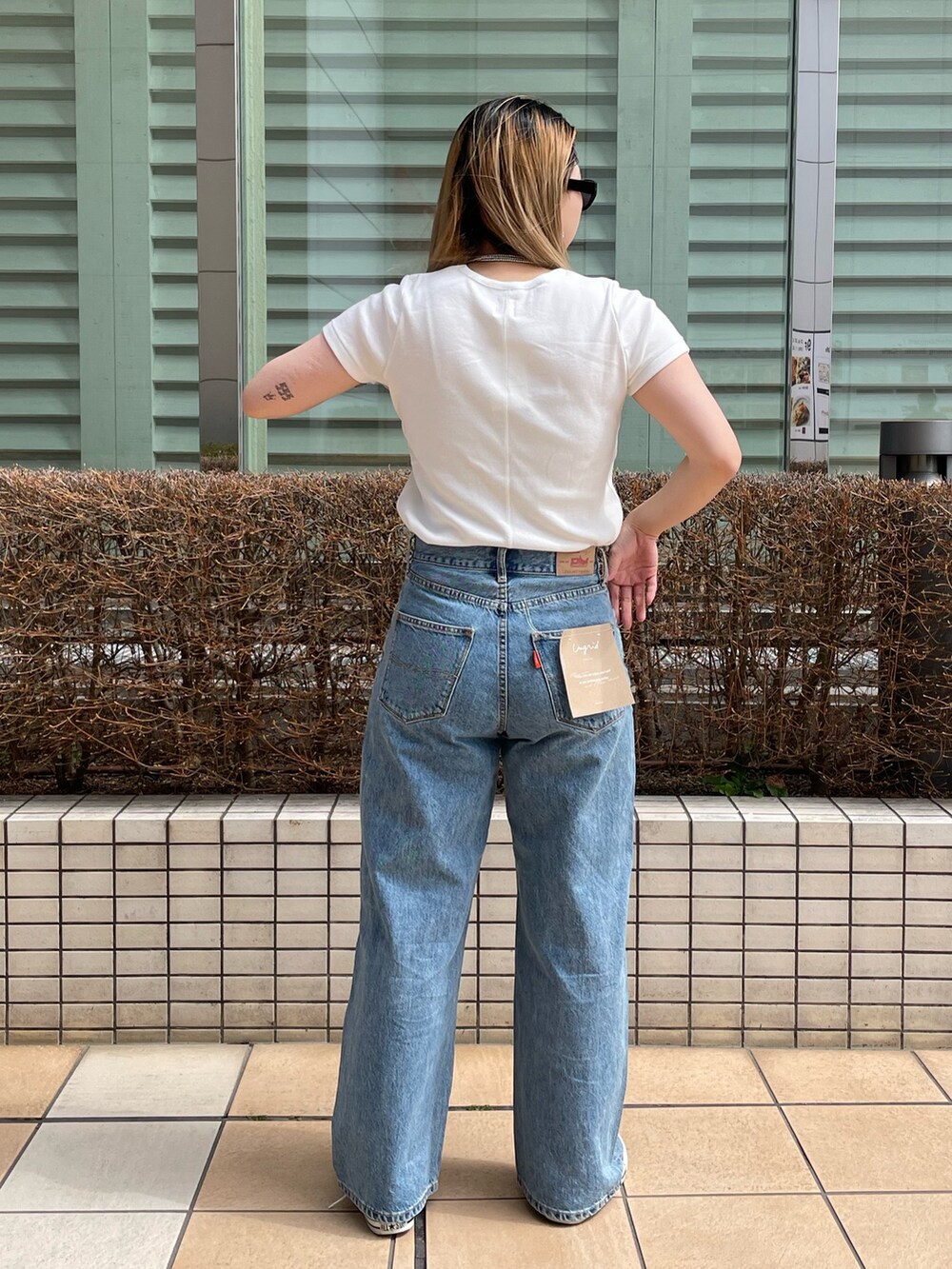 ブルー系のデニムパンツ、ホワイト系のTシャツ/カットソー、シルバー系のネックレスを着用したレディースの春コーディネートの4枚目の写真