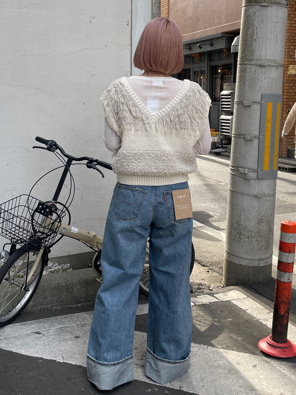 ブルー系のデニムパンツ、ホワイト系のベスト、ホワイト系のTシャツ/カットソーを着用したレディースの冬コーディネートの3枚目の写真