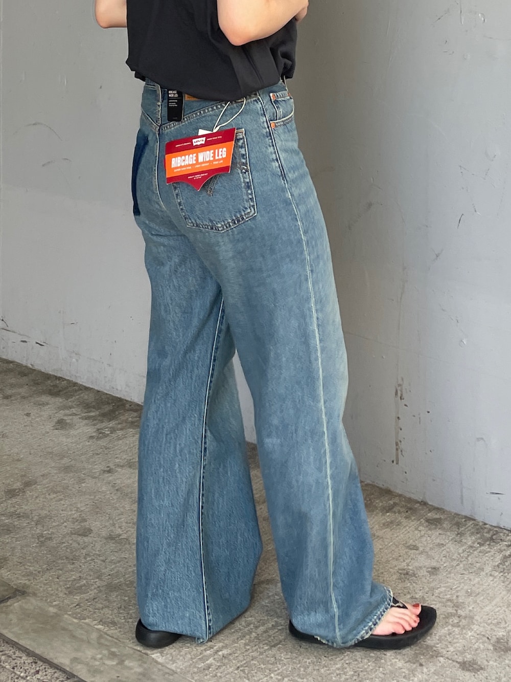 ブルー系のデニムパンツ、グレー系のタンクトップを着用したレディースの夏コーディネートの6枚目の写真