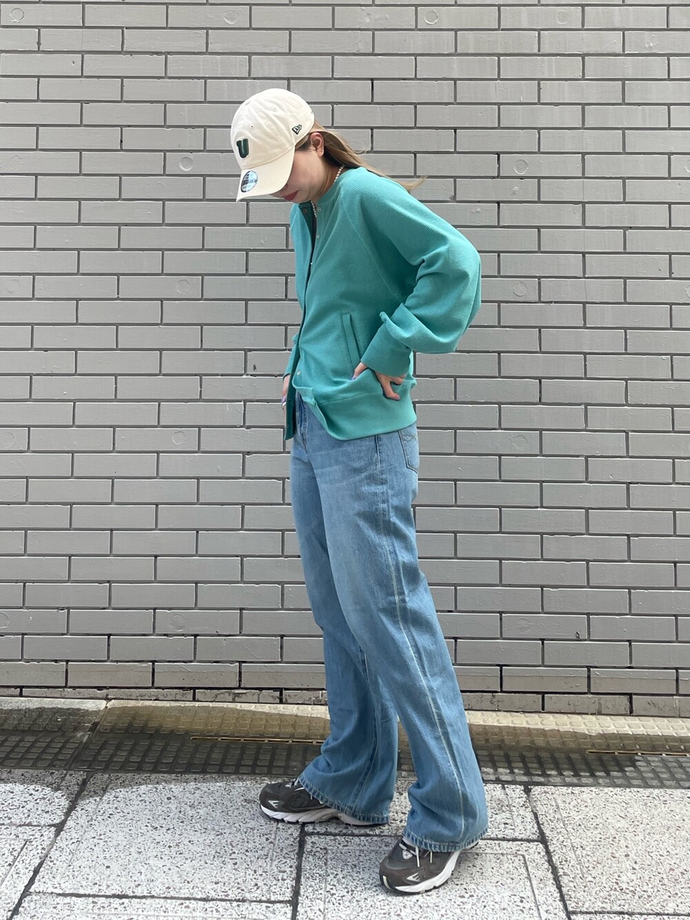 ブルー系のカーディガン/ボレロ、ブルー系のデニムパンツ、ホワイト系のキャップを着用したレディースの冬コーディネートの3枚目の写真