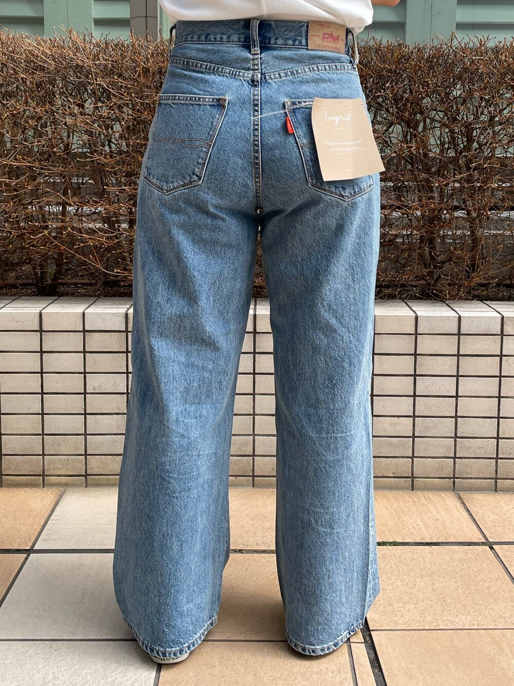 ブルー系のデニムパンツ、ホワイト系のTシャツ/カットソー、シルバー系のネックレスを着用したレディースの春コーディネートの7枚目の写真