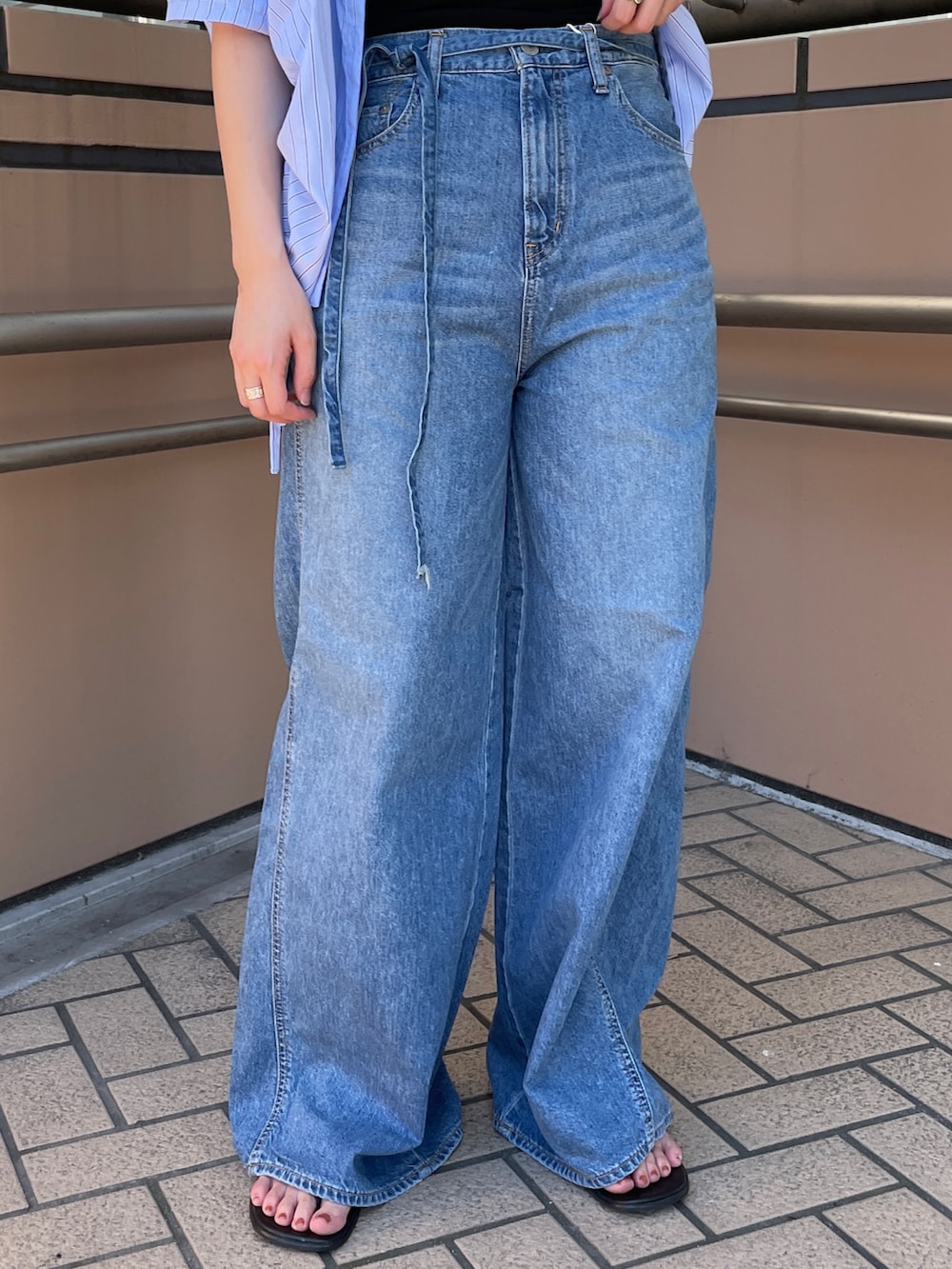 ブルー系のデニムパンツ、ブルー系のシャツ/ブラウス、ブラック系のキャミソールを着用したレディースの夏コーディネートの4枚目の写真