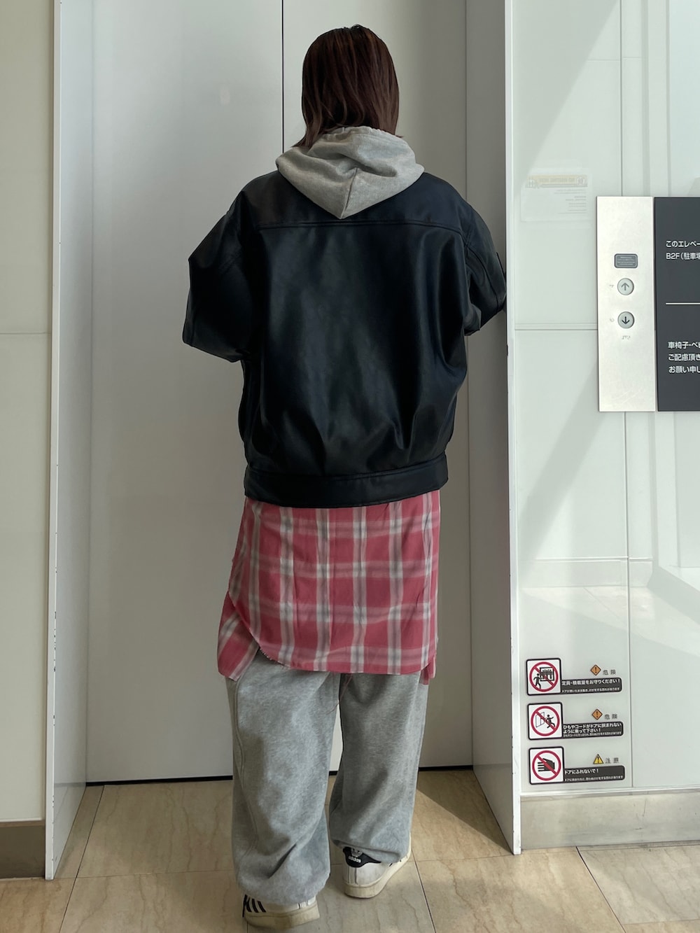 ブラック系のブルゾン、グレー系のパーカー、レッド系のシャツ/ブラウスを着用したレディースの冬コーディネートの3枚目の写真