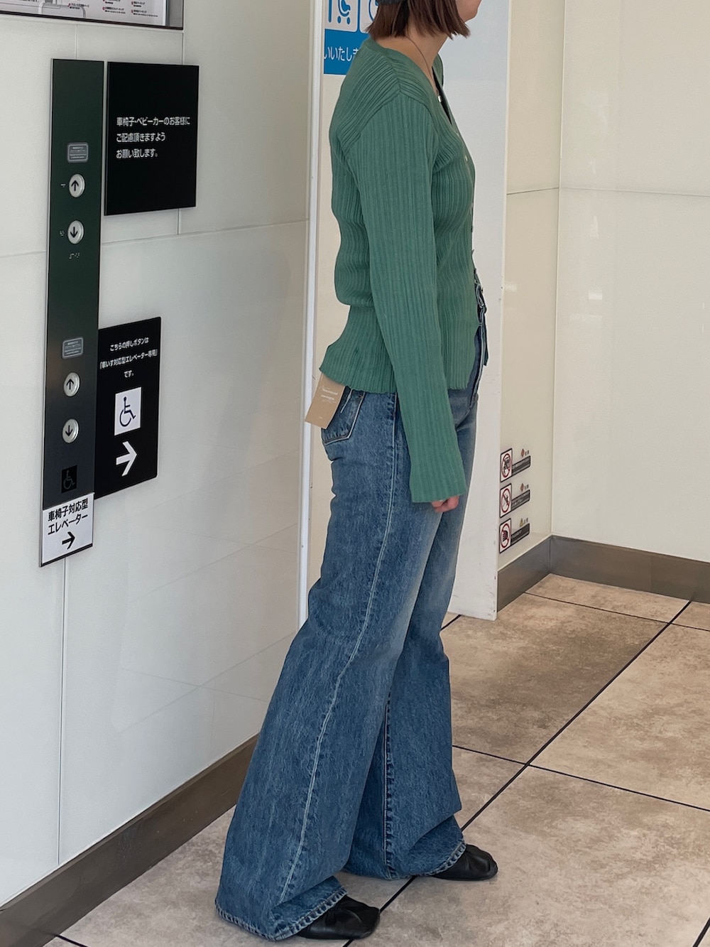 グリーン系のカーディガン/ボレロ、ブルー系のデニムパンツ、グレー系のニットキャップ/ビーニーを着用したレディースの春コーディネートの2枚目の写真