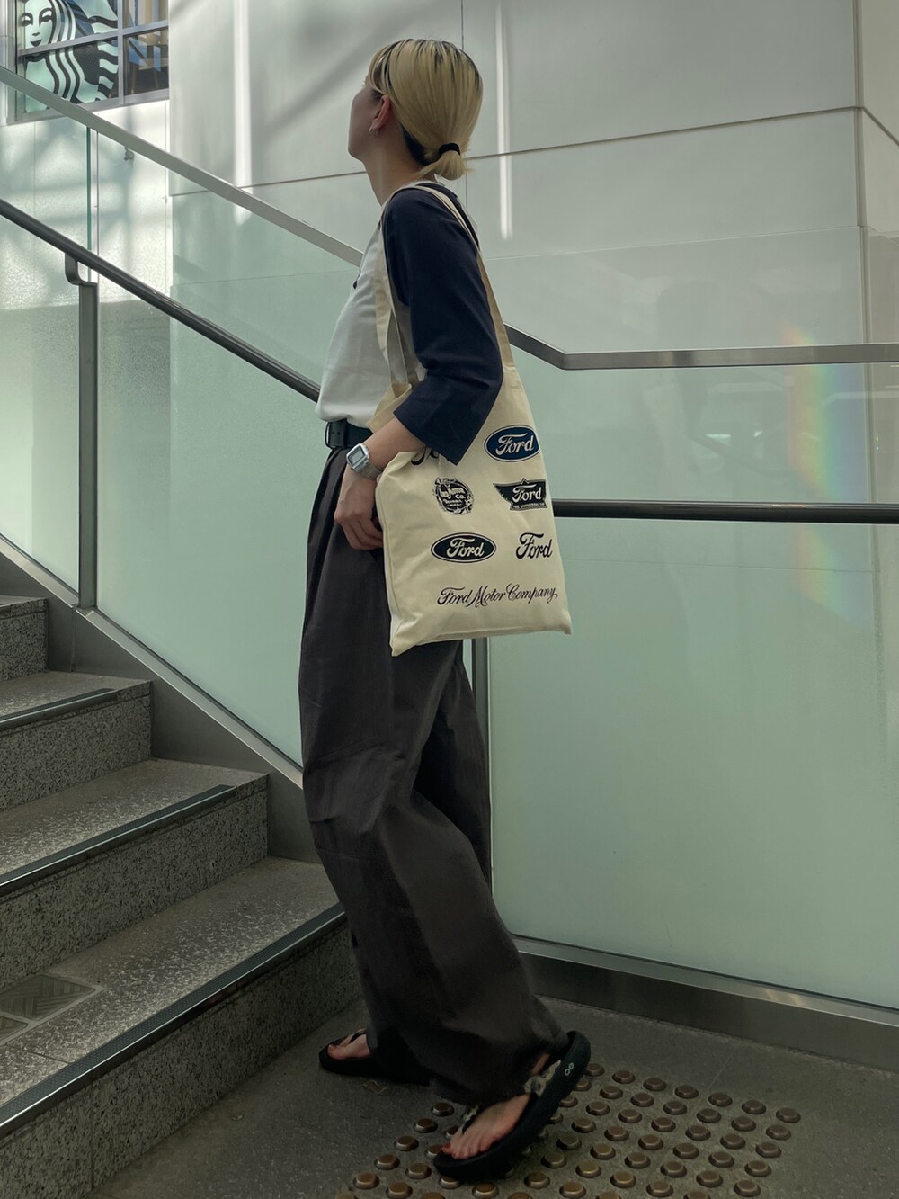 ブルー系のTシャツ/カットソー、ホワイト系のトートバッグ、グレー系のチノパンツを着用したレディースの夏コーディネートの2枚目の写真